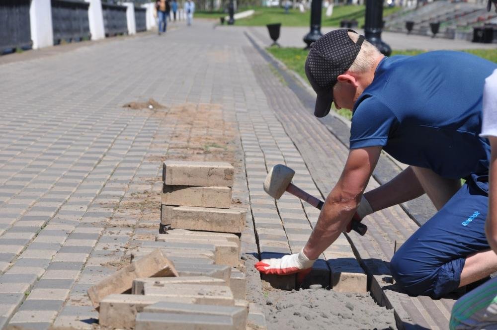 Услуги по укладке тротуарной плитки. Укладка тротуарной плитки рабочие. Рабочие на тротуарную плитку. Укладка дорожной плитки. Человек с брусчаткой.