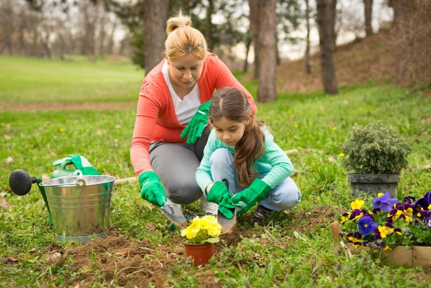 Planting flowers. Семья в саду. Уборка сада. Трудятся в саду семья. Работа в саду.